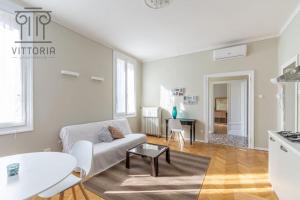 a living room with a white couch and a table at Vittoria Apartments: Viale Dante in Vicenza