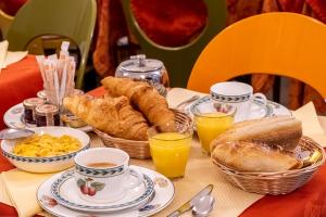 パリにあるホテル ボドレール オペラのパン、スクランブルエッグ、オレンジジュースを用意したテーブル