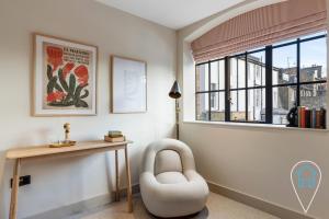 um quarto com uma secretária e uma cadeira ao lado de uma janela em Modern 1BR home in Islington! em Londres