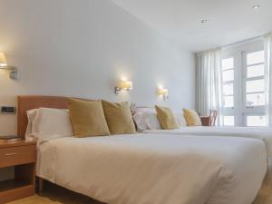 卢戈Hostal ALBA Lugo的有两张床和一扇窗户的酒店房间