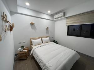 um quarto com uma grande cama branca e uma janela em 宸村民宿 em Dongshan mais 41 fotografias