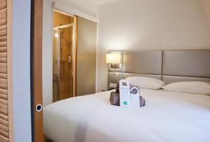 une chambre d'hôtel dotée d'un lit avec une boîte. dans l'établissement HOTEL AMBASSADEUR, à Lille