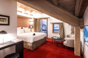 a hotel room with a bed and a desk and chairs at Hôtel L'Aigle du Montana by Les Etincelles in Tignes