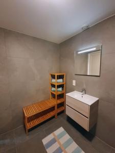 a bathroom with a sink and a mirror and a shelf at De Bloemenkwekerij in Egmond-Binnen