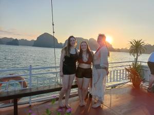 a group of people standing on a boat in the water at Tom's Family Hotel in Ha Long