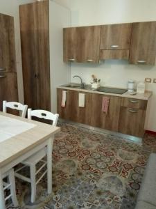 eine Küche mit Holzschränken sowie einem Tisch und Stühlen in der Unterkunft Villa Mezzetti in Petrignano sul Lago