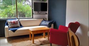 sala de estar con sofá, mesa y 2 sillas en Tu Apart en Bariloche 22 en San Carlos de Bariloche