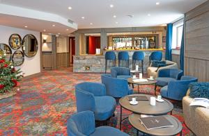une salle d'attente avec des chaises bleues et un bar dans l'établissement Hôtel L'Aigle du Montana by Les Etincelles, à Tignes
