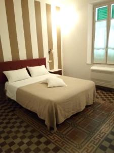a bedroom with a large bed with white sheets and a window at Villa Mezzetti in Petrignano sul Lago