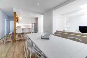 een keuken en een woonkamer met een tafel en stoelen bij Rua da Praia in Póvoa de Varzim