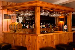 un bar in legno con molte bottiglie di vino di Hosteria La Camila a Villa La Angostura