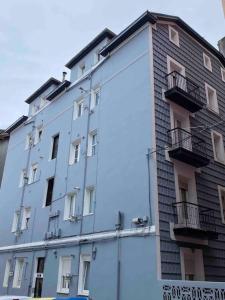 un edificio alto de color blanco con balcones en un lateral. en Santander Jiménez Díaz 7B, en Santander