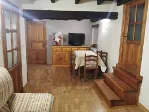 a dining room with a table and a tv at CASA DE LOS ABUELOS in Espinama