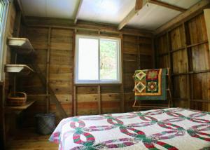 a bedroom with a quilt on a bed and a window at The Birds Nest in Bocas del Toro