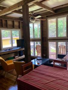 uma sala de estar com uma mesa, cadeiras e janelas em The Birds Nest em Bocas del Toro