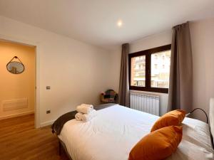 um quarto com uma cama com duas almofadas e uma janela em Espot Cowork & Apartments em Espot