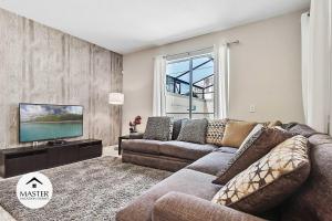 uma sala de estar com um sofá e uma televisão de ecrã plano em 4 Bedrooms 3 Bathrooms Storey Lake 4925 Wa em Kissimmee