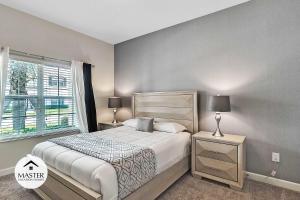 um quarto com uma cama grande e uma janela em 4 Bedrooms 3 Bathrooms Storey Lake 4925 Wa em Kissimmee