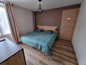 a bedroom with a bed with blue sheets and a window at la villageoise in Leignes-sur-Fontaine