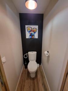 a bathroom with a toilet and a painting on the wall at la villageoise in Leignes-sur-Fontaine