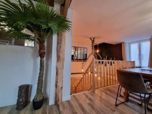 a dining room with a table and a palm tree at la villageoise in Leignes-sur-Fontaine