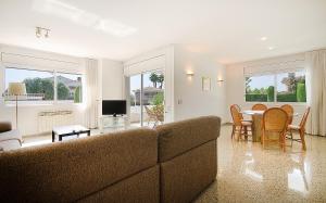 een woonkamer met een bank en een tafel en stoelen bij R11 Casa Blanca con gran jardin y piscina in Calafell