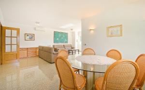 een woonkamer met een tafel en stoelen en een bank bij R11 Casa Blanca con gran jardin y piscina in Calafell