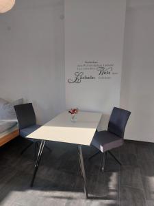 uma mesa branca e duas cadeiras num quarto em Apartments im Mardefeldpalais em Ansbach