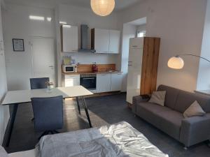 uma cozinha e sala de estar com um sofá e uma mesa em Apartments im Mardefeldpalais em Ansbach