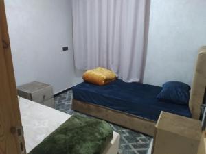 ein kleines Zimmer mit 2 Betten und einem Fenster in der Unterkunft إقامة الخيمة للشقق المفروشة in El Aaiún