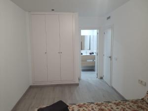 a white room with a bed and a bathroom at Modern & sunny apartment near Valencia in Paiporta