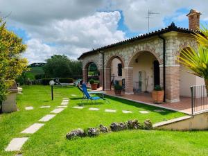 un jardín con un edificio de piedra y un patio en 8380 Agriturismo L'Oleandro, en Montemerano