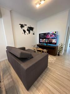 uma sala de estar com um sofá e uma televisão de ecrã plano em Departamento temporal con cochera em Santa Fé