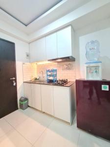uma cozinha com armários brancos e um frigorífico em D05-2BR Grand Asia Afrika Residence em Bandung