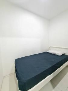 uma cama num quarto branco com um colchão azul em D05-2BR Grand Asia Afrika Residence em Bandung