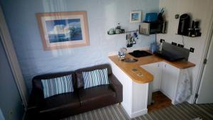 a room with a desk with a couch and a computer at Studio 2 in Newquay
