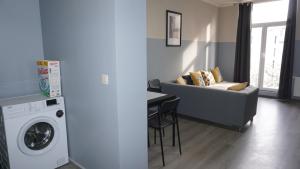 a living room with a couch and a washing machine at Apartments Plantin 3 sleeping rooms 2 bathrooms. in Antwerp