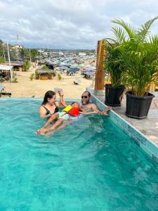 a man and a woman in a swimming pool at Muyuyo Lodge in Ayangue