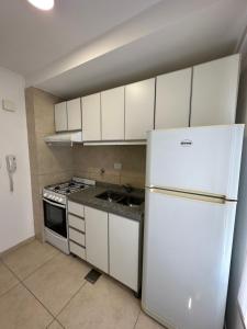 a kitchen with a white refrigerator and a sink at NGL - Departamento temporal con cochera in Santa Fe +12 photos