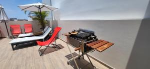 une terrasse avec une table, des chaises et un parasol dans l'établissement L & P Apart Punta Hermosa, à Punta Hermosa