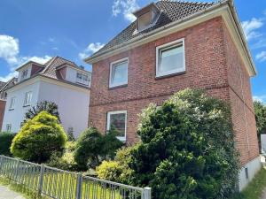 a brick house with a fence in front of it at Modern und ruhig in Elmshorn in Elmshorn