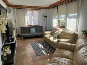 een woonkamer met een bank en een televisie bij Apartamentos casa luis in Suances