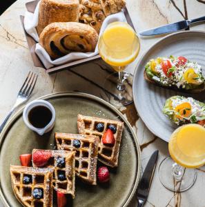 a table with two plates of waffles and breakfast foods at The St. Regis Toronto in Toronto