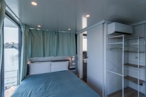 a small bedroom with a bed and a window at La Dolce Vita House Boat in Lisanza