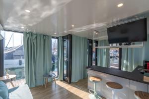 a living room with a tv and some windows at La Dolce Vita House Boat in Lisanza