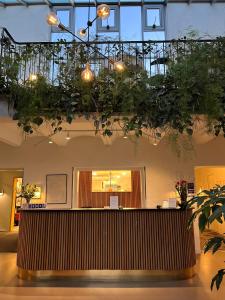 a lobby with a reception desk with plants on the ceiling at Hotel Dalgas in Brande