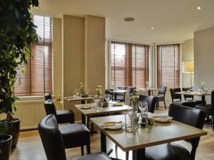 オックスフォードにあるLinton Lodge a BW Signature Collection Hotelのテーブルと椅子、窓のあるレストラン