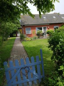ein blauer Zaun vor einem Haus in der Unterkunft Kleine Scholle in Neuharlingersiel