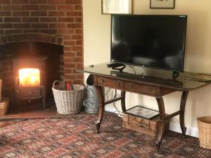 StanhoeにあるThe Barnのリビングルーム(暖炉付)のテーブルにテレビが備わります。