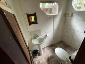 un piccolo bagno con lavandino e WC di Suíte aconchegante Chalé do cerrado na Villa de São Jorge, venha viver essa experiência!! a Alto Paraíso de Goiás